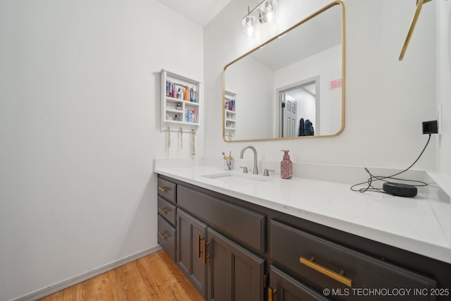 bathroom featuring vanity, baseboards, and wood finished floors