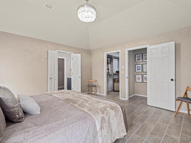 bedroom featuring baseboards, an inviting chandelier, vaulted ceiling, a walk in closet, and visible vents