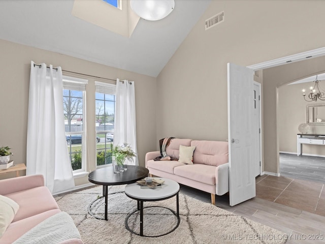 living area with high vaulted ceiling, visible vents, a chandelier, wood tiled floor, and baseboards