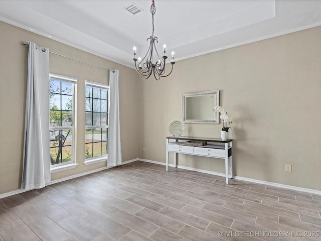 empty room with wood finished floors, an inviting chandelier, baseboards, and visible vents