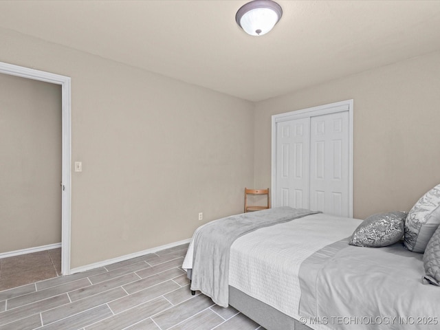 bedroom featuring a closet, baseboards, and wood finish floors