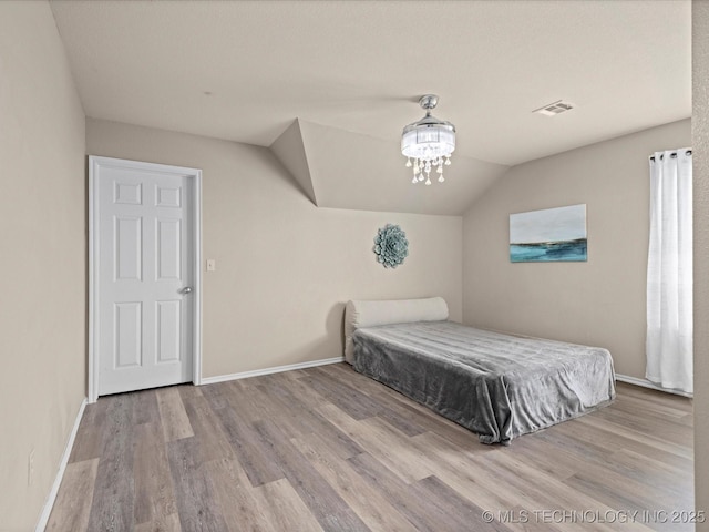 3017 Lincoln Rd, Bartlesville, OK 74006 - bedroom featuring wood finished floors, baseboards, lofted ceiling, and a chandelier