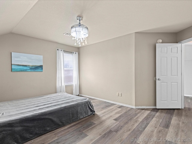 3017 Lincoln Rd, Bartlesville, OK 74006 - bedroom with wood finished floors, a chandelier, and lofted ceiling