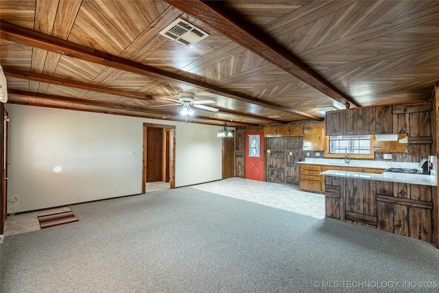 703 N Sioux Ave, Claremore, OK 74017 - kitchen with ceiling fan, open floor plan, brown cabinetry, light colored carpet, and light countertops