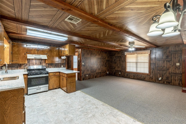 703 N Sioux Ave, Claremore, OK 74017 - kitchen featuring stainless steel gas stove, under cabinet range hood, brown cabinetry, wooden walls, and wood ceiling