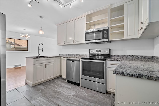 5729 E 24th Pl S, Tulsa, OK 74114 - kitchen featuring open shelves, stainless steel appliances, a sink, visible vents, and a peninsula