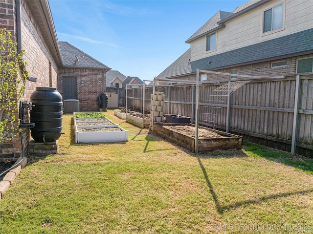 view of yard featuring central AC, a fenced backyard, and a garden