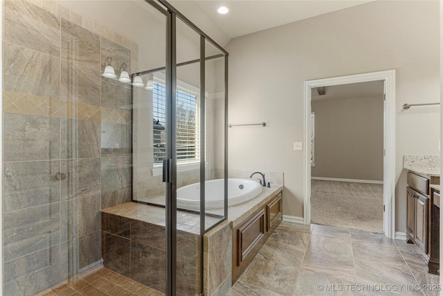 full bathroom with a garden tub, a stall shower, vanity, and baseboards