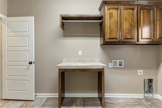 laundry area featuring electric dryer hookup, washer hookup, cabinet space, and baseboards