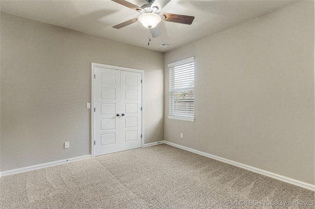 unfurnished room featuring visible vents, a ceiling fan, baseboards, and carpet floors
