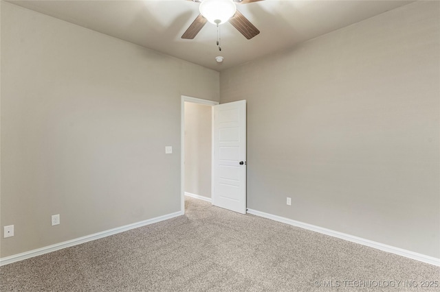 carpeted empty room featuring baseboards and a ceiling fan