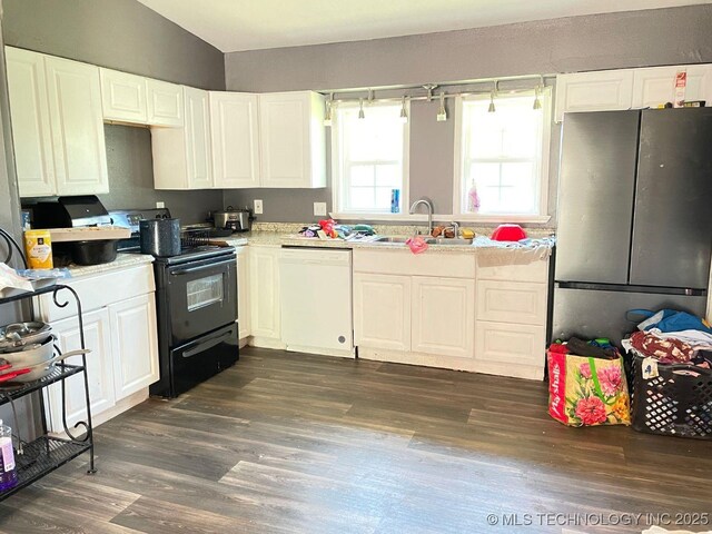 kitchen featuring white cabinetry, a sink, freestanding refrigerator, white dishwasher, and black electric range