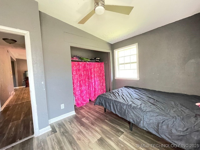 bedroom featuring baseboards, vaulted ceiling, wood finished floors, and a ceiling fan