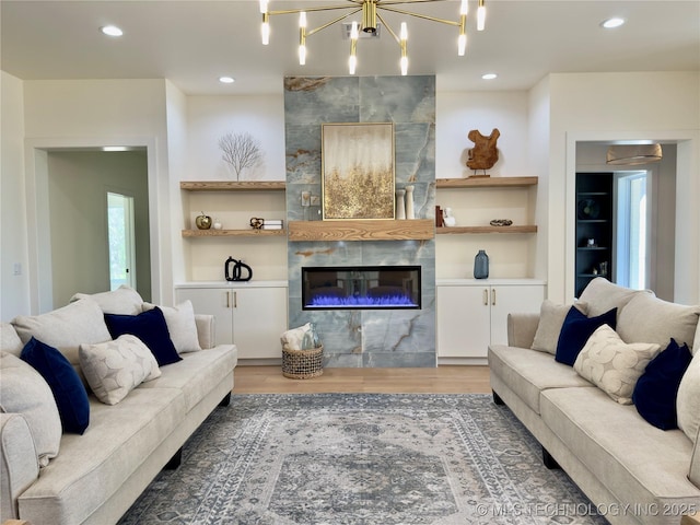 30303 E 59th St S, Broken Arrow, OK 74014 - living room with built in shelves, light wood-style flooring, a tiled fireplace, recessed lighting, and a chandelier