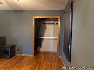 unfurnished bedroom with baseboards and wood finished floors