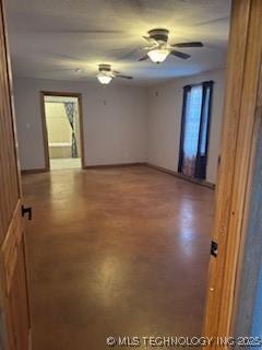 empty room featuring finished concrete flooring, a wealth of natural light, and ceiling fan