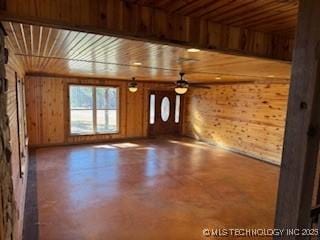unfurnished living room with a ceiling fan and concrete flooring