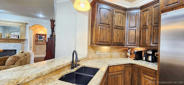 870 Cherry Springs Dr, Tahlequah, OK 74464 - kitchen featuring stainless steel fridge, crown molding, light stone countertops, tasteful backsplash, and a fireplace