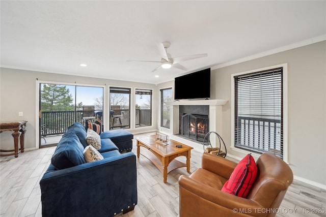 42 Diamond Head Dr Unit 42, Sand Springs, OK 74063 - living area featuring ornamental molding, a ceiling fan, light wood finished floors, a lit fireplace, and baseboards
