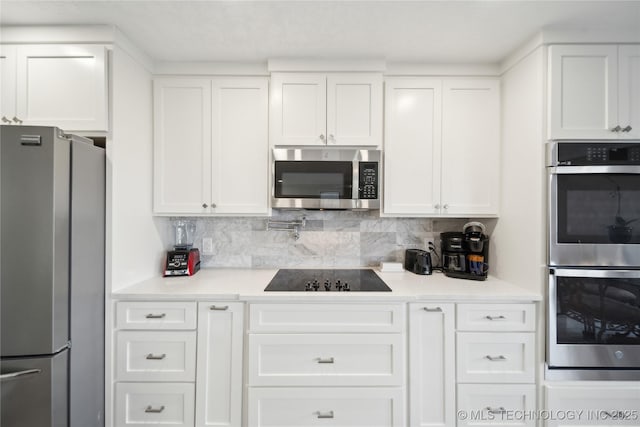 42 Diamond Head Dr Unit 42, Sand Springs, OK 74063 - kitchen featuring appliances with stainless steel finishes, white cabinetry, light countertops, and tasteful backsplash