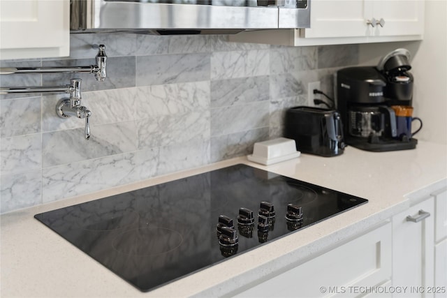 42 Diamond Head Dr Unit 42, Sand Springs, OK 74063 - kitchen featuring black electric stovetop, decorative backsplash, white cabinets, and light stone countertops