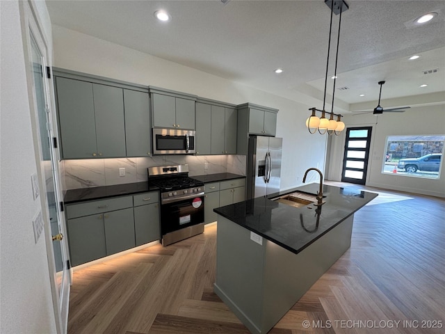 3204 N Hartford Ave, Tulsa, OK 74106 - kitchen with tasteful backsplash, appliances with stainless steel finishes, a sink, gray cabinetry, and pendant lighting