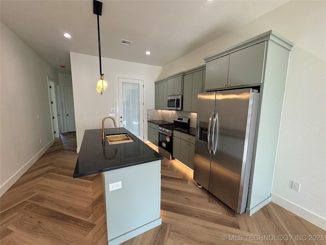 3204 N Hartford Ave, Tulsa, OK 74106 - kitchen featuring an island with sink, a sink, appliances with stainless steel finishes, visible vents, and dark countertops