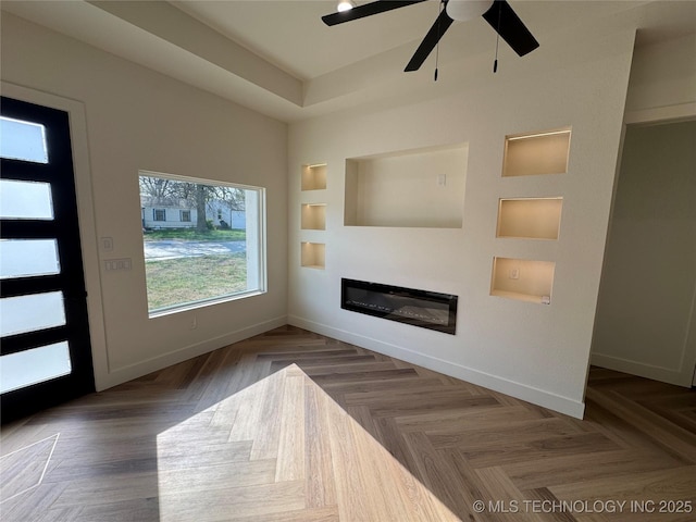 3204 N Hartford Ave, Tulsa, OK 74106 - unfurnished living room featuring baseboards, a glass covered fireplace, built in features, and a ceiling fan