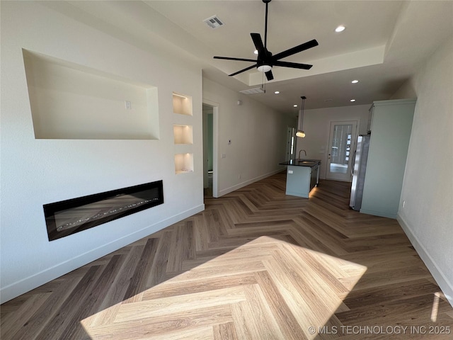 3204 N Hartford Ave, Tulsa, OK 74106 - unfurnished living room with a sink, a glass covered fireplace, baseboards, visible vents, and recessed lighting