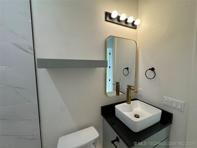 3204 N Hartford Ave, Tulsa, OK 74106 - bathroom featuring a textured wall, toilet, and vanity