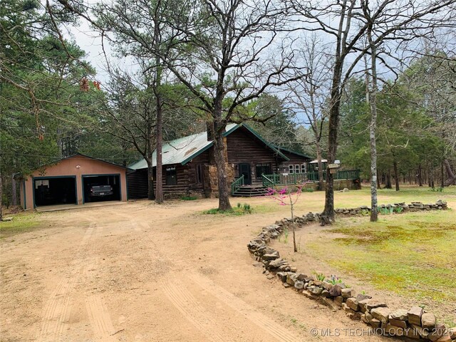 413822 S Sherman, Moyers, OK 74557 - view of front of house featuring log siding, driveway, and a garage