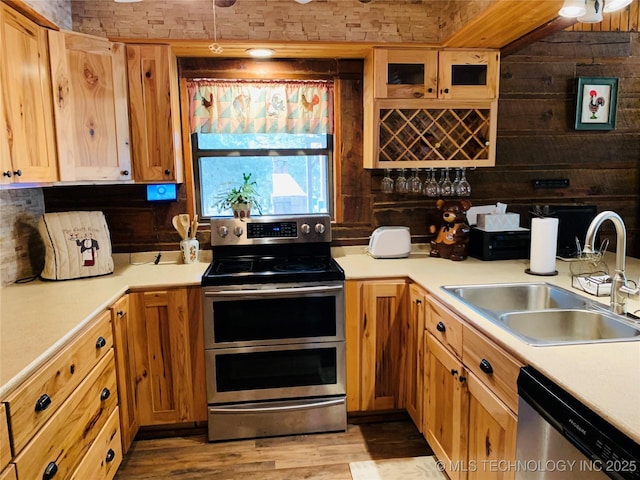 413822 S Sherman, Moyers, OK 74557 - kitchen with light countertops, a sink, wooden walls, appliances with stainless steel finishes, and light wood-style floors