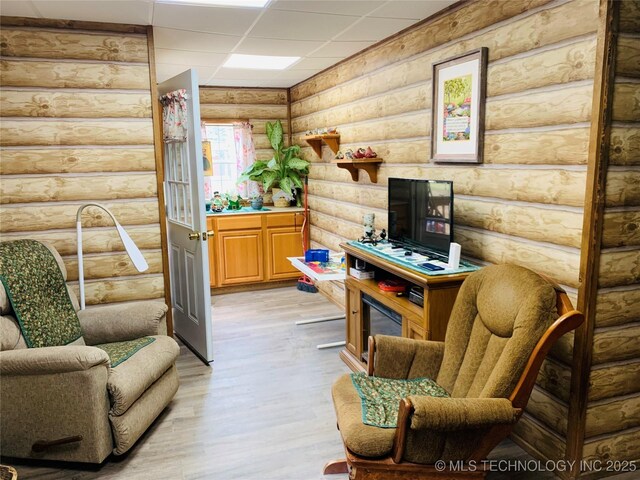 413822 S Sherman, Moyers, OK 74557 - living area featuring light wood-style flooring, log walls, and a paneled ceiling