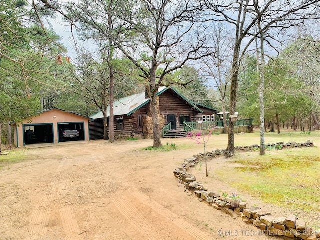 413822 S Sherman, Moyers, OK 74557 - log-style house with log siding, a detached garage, and dirt driveway