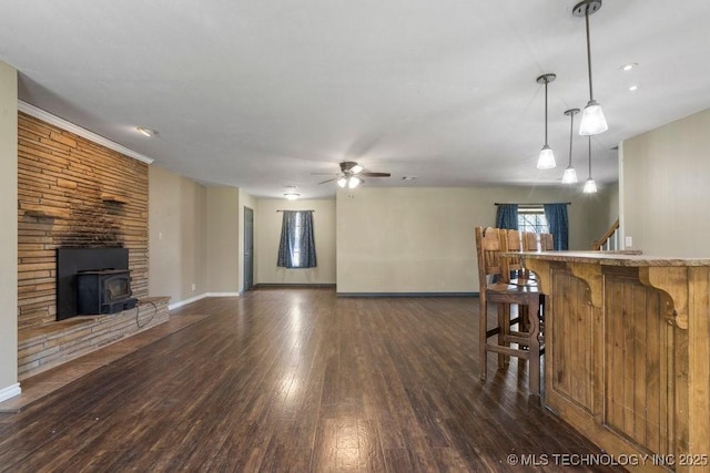 9012 S 49th W Ave, Tulsa, OK 74131 - living area featuring a wood stove, dark wood-style flooring, baseboards, and a ceiling fan