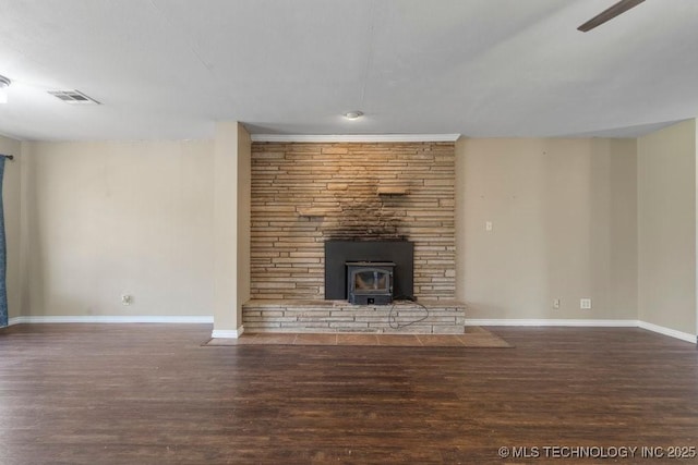 9012 S 49th W Ave, Tulsa, OK 74131 - unfurnished living room featuring baseboards, a wood stove, visible vents, ceiling fan, and wood finished floors