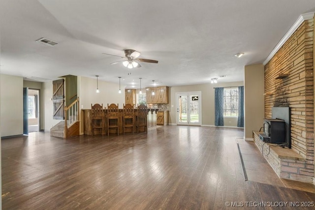 9012 S 49th W Ave, Tulsa, OK 74131 - living area featuring visible vents, baseboards, a wood stove, a ceiling fan, and wood finished floors