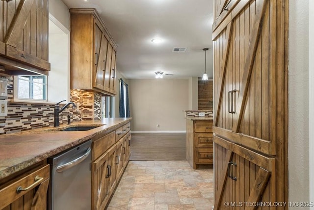 9012 S 49th W Ave, Tulsa, OK 74131 - kitchen with baseboards, backsplash, stone finish floor, dishwasher, and a sink