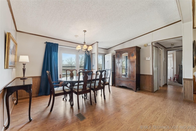 20136 W Chicken Creek Rd, Cookson, OK 74427 - dining room featuring ornamental molding, a wainscoted wall, a chandelier, a textured ceiling, and light wood-style flooring