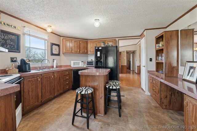 20136 W Chicken Creek Rd, Cookson, OK 74427 - kitchen featuring black appliances, ornamental molding, a center island, a kitchen bar, and a textured ceiling