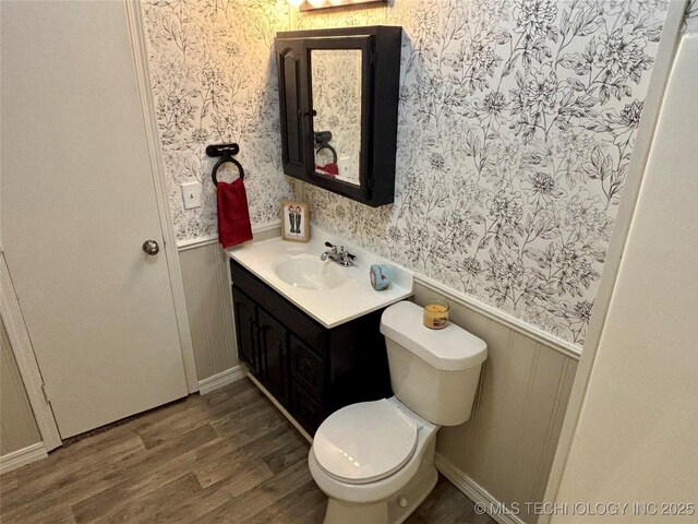 112 S 7th St, Eufaula, OK 74432 - bathroom with wainscoting, vanity, wallpapered walls, wood finished floors, and toilet