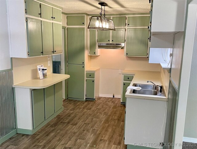 112 S 7th St, Eufaula, OK 74432 - kitchen featuring green cabinets, under cabinet range hood, a sink, dark wood-style flooring, and a textured ceiling