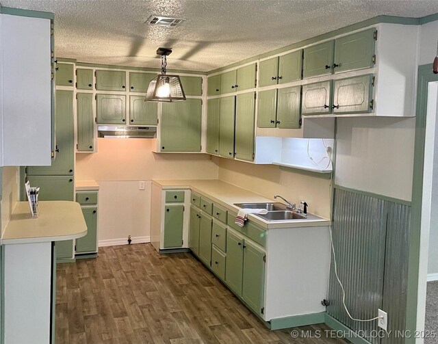112 S 7th St, Eufaula, OK 74432 - kitchen featuring green cabinets, a textured ceiling, under cabinet range hood, a sink, and dark wood-type flooring