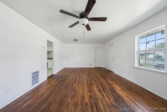 empty room featuring visible vents, ceiling fan, and wood finished floors
