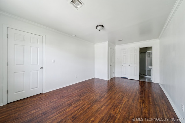 unfurnished room featuring crown molding, wood finished floors, baseboards, and visible vents