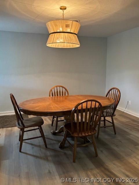 dining space with dark wood-style flooring and baseboards