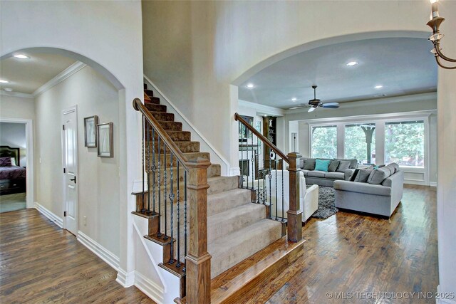 7415 E 109th St S, Tulsa, OK 74133 - stairway featuring wood finished floors, baseboards, arched walkways, ceiling fan, and ornamental molding