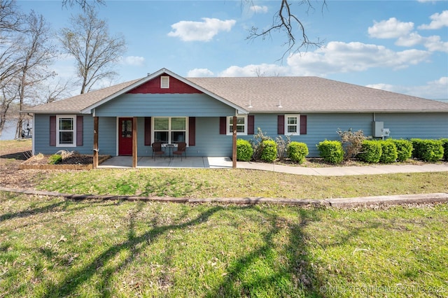 single story home featuring a shingled roof and a front lawn