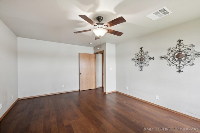 unfurnished room with baseboards, dark wood-style flooring, ceiling fan, and visible vents