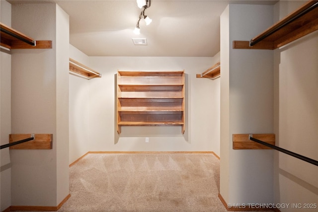 walk in closet featuring visible vents and carpet flooring